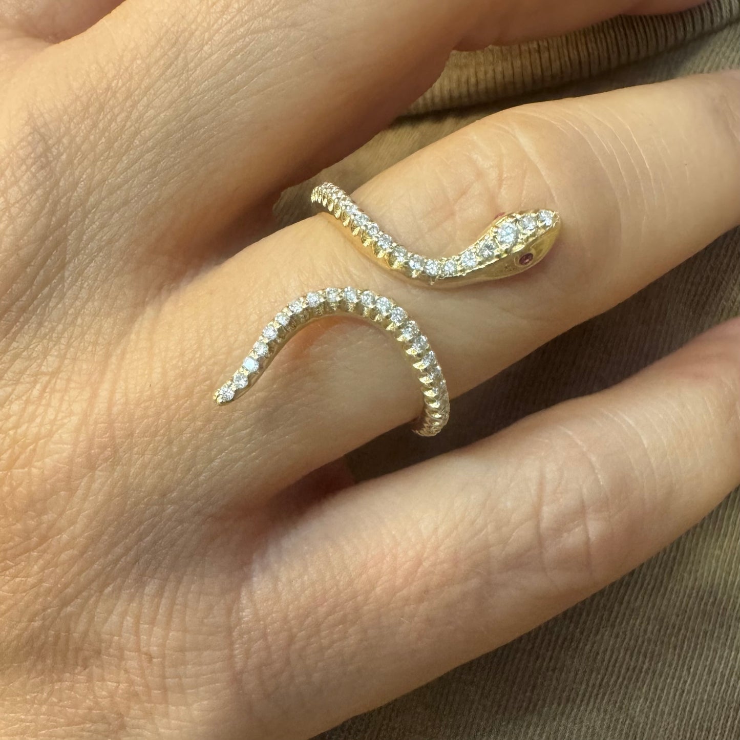 14K gold wrap-around snake ring, fully set with sparkling Diamonds along its body and head, finished with Rubies eyes