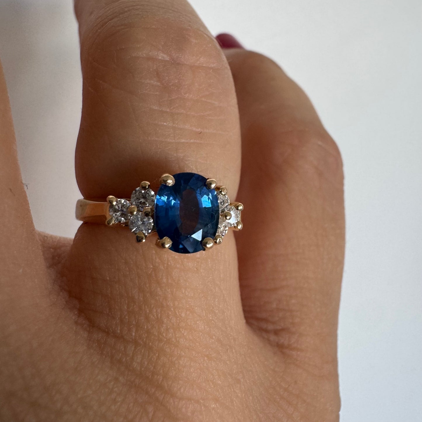 14K gold ring set with an oval blue Sapphire at the center & Diamonds