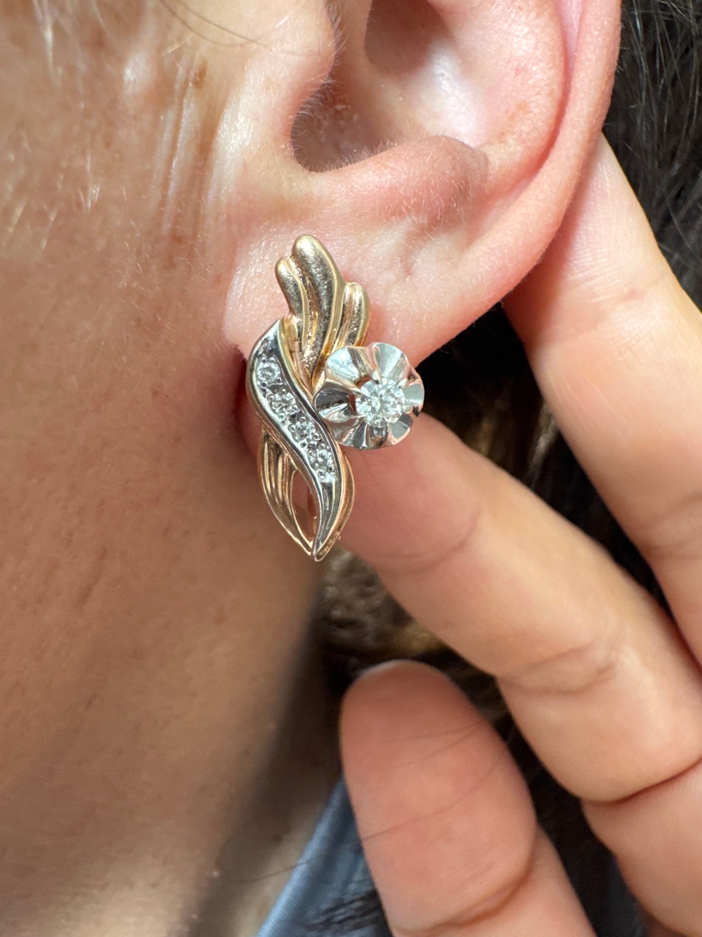 עגילי זהב 14 קראט בעיצוב מתעגל ואלגנטי המשובצים יהלומים נוצצים .