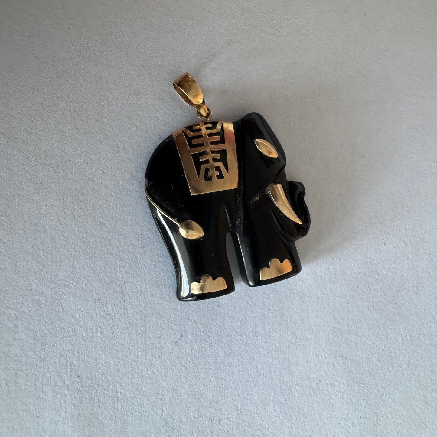 תליון זהב 9 קראט בעיצוב ייחודי ומלא נוכחות של פיל אפריקאי, המשלב גוף שחור מלוטש עם עיטורי זהב עדינים.