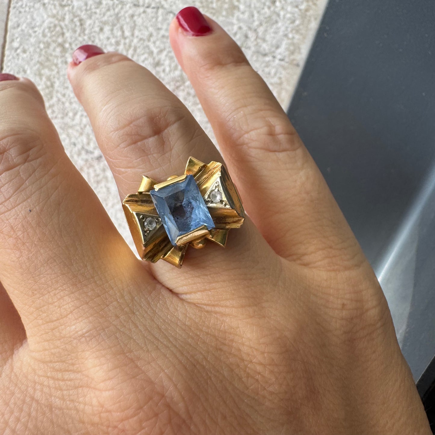 טבעת זהב צהוב 18 קראט בעיצוב פפיון משובצת אבן טופז כחולה בחיתוך מלבני במרכז