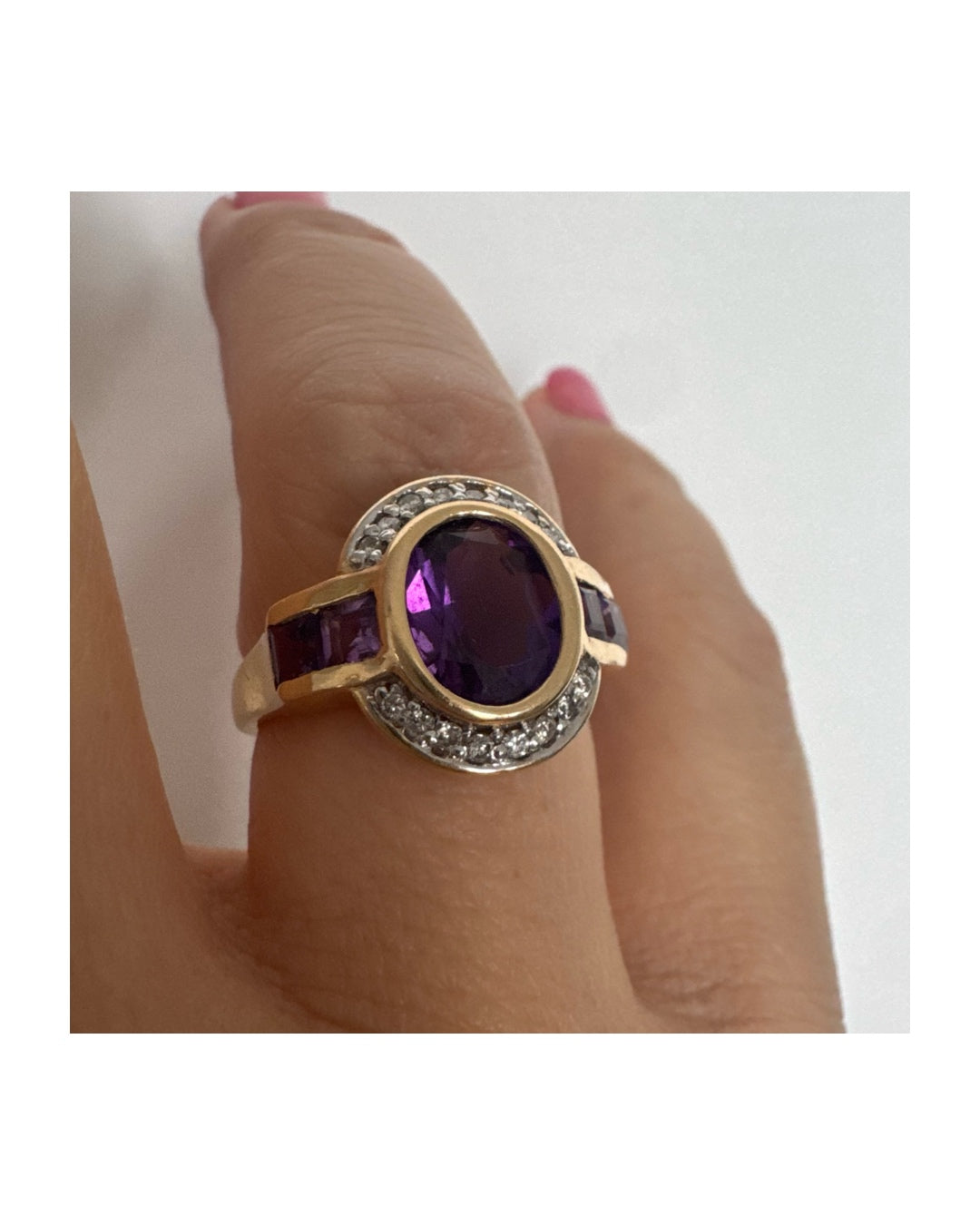 טבעת זהב 14 קראט בעיצוב ייחודי עם אבן אמטיסט אובלית מרכזית בגוון סגול עמוק, משובצת במסגרת חלקה ומודגשת ויהלומים.