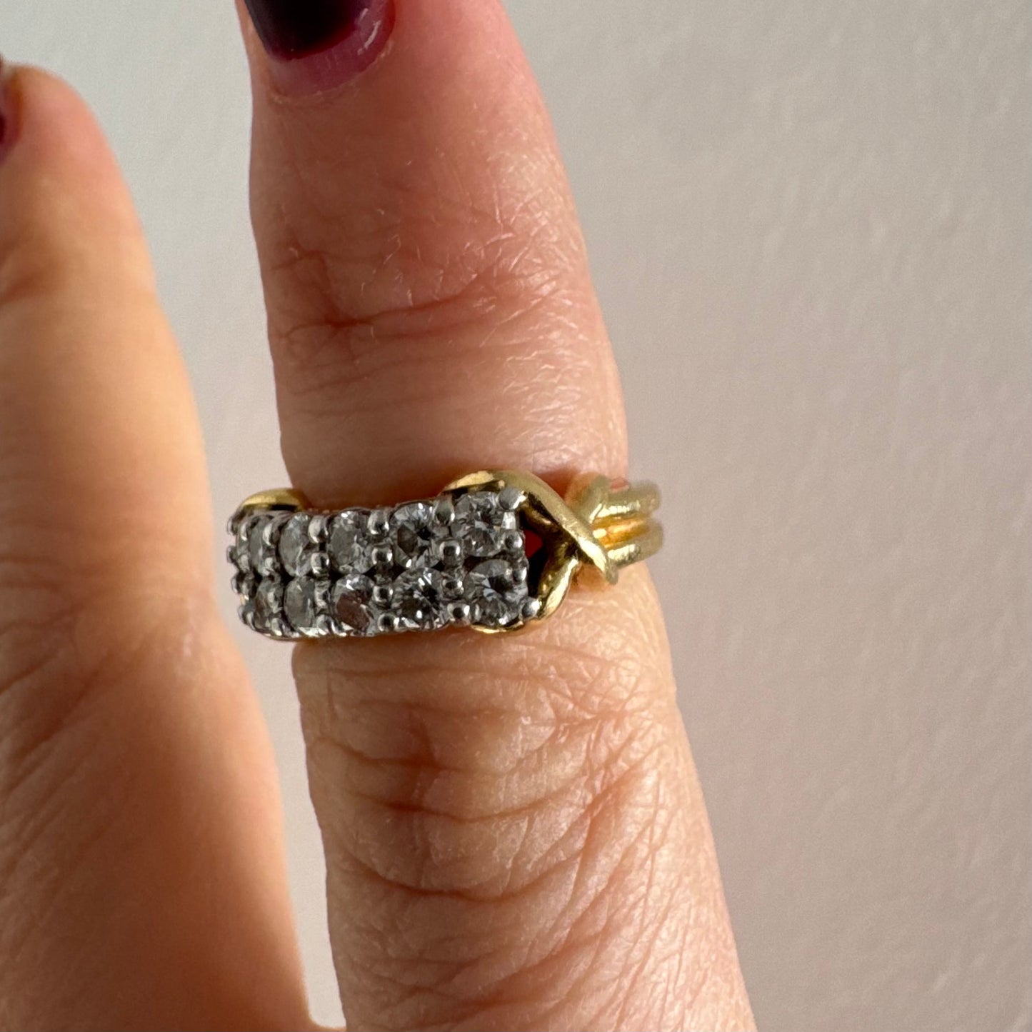 טבעת זהב צהוב 18 קראט משובצת יהלומים עגולים בשתי שורות צפופות, במבנה מלבני מעוגל.