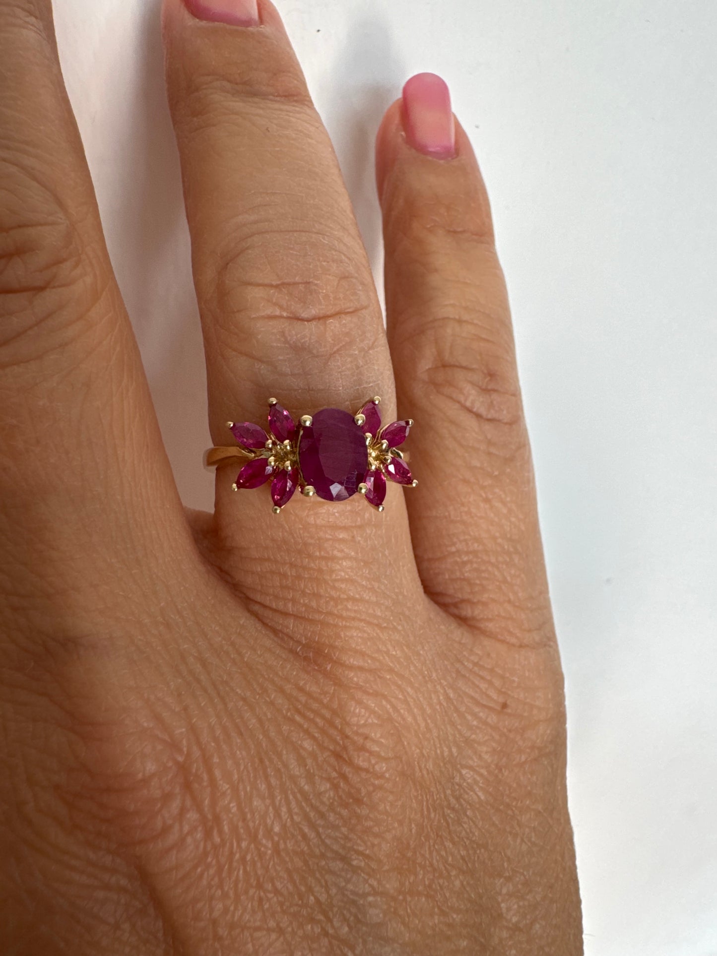 טבעת זהב צהוב 14 קראט משובצת רובי מרכזי גדול ולצידו רובי בחיתוך מרקיזה בעיצוב פרחוני עשיר.