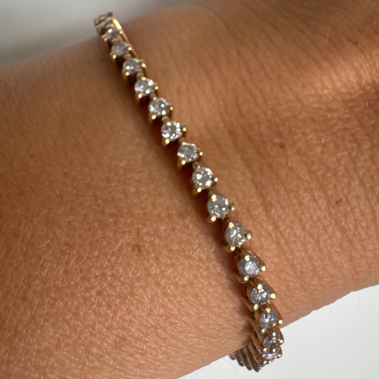 14K gold tennis bracelet set with a continuous line of round Diamonds, creating a delicate and elegant sparkle.
