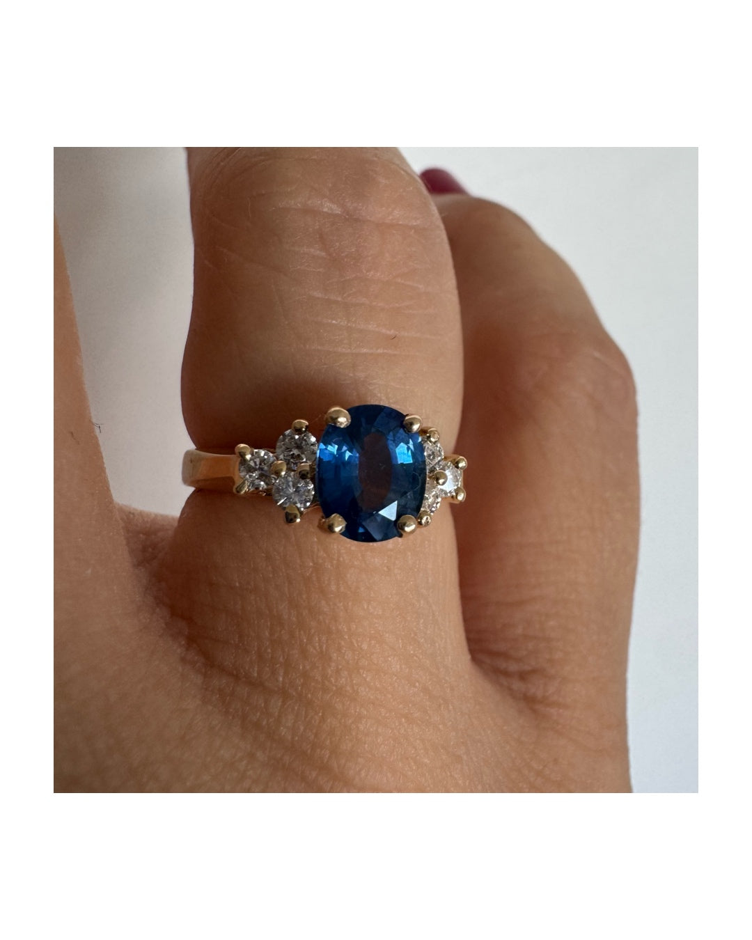 14K gold ring set with an oval blue Sapphire at the center & Diamonds