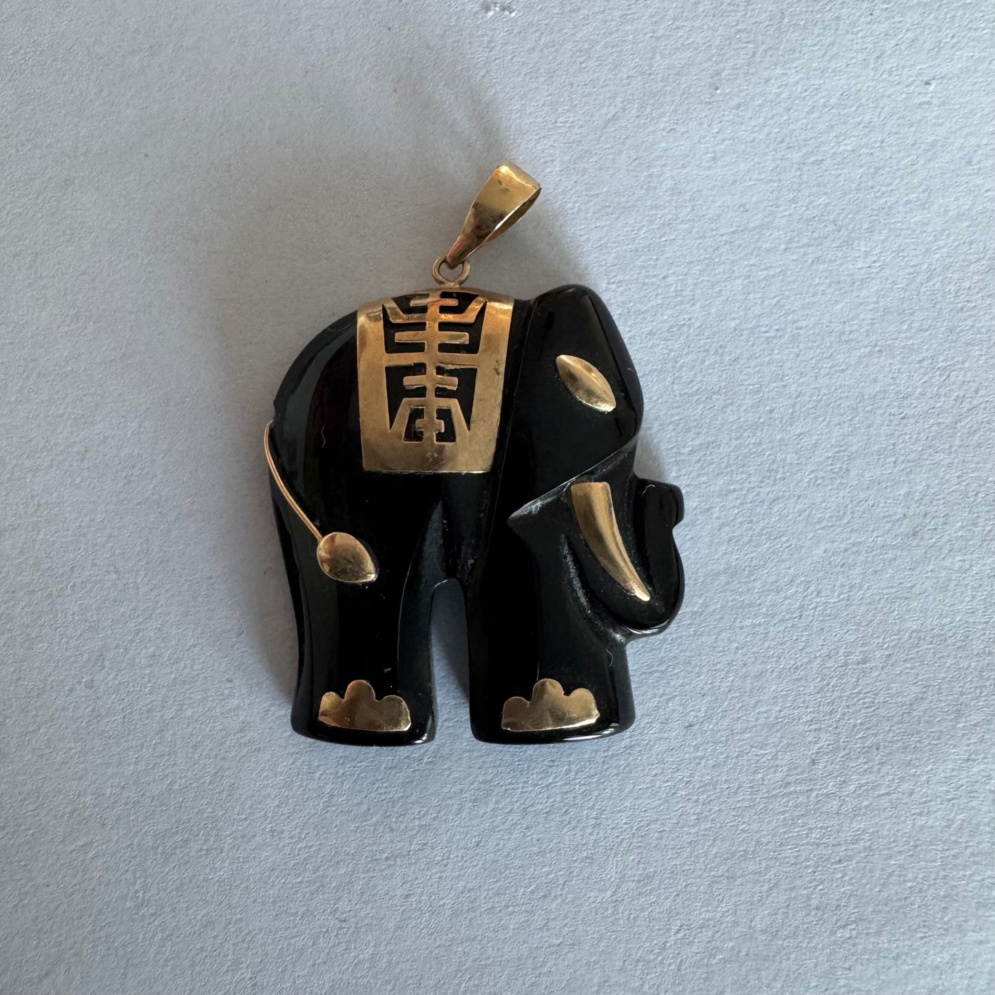 תליון זהב 9 קראט בעיצוב ייחודי ומלא נוכחות של פיל אפריקאי, המשלב גוף שחור מלוטש עם עיטורי זהב עדינים.