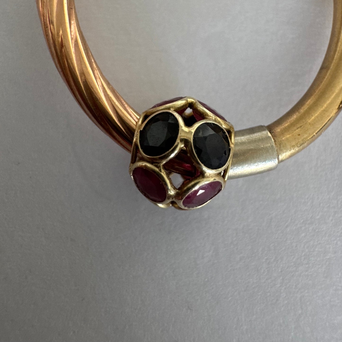 10K gold hoop earrings with a twisted design, set with pink and green Tourmaline.