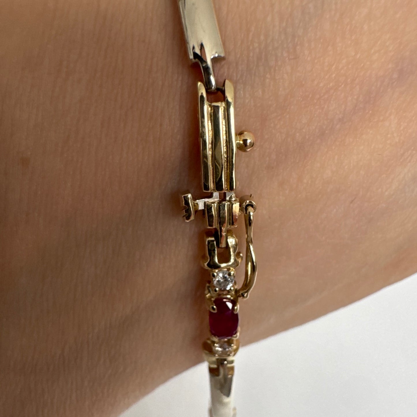צמיד זהב צהוב 14 קראט משובץ אבני רובי אדומות בחיתוך אובלי, עם יהלומים המשובצים ביניהן להוספת ברק עדין.