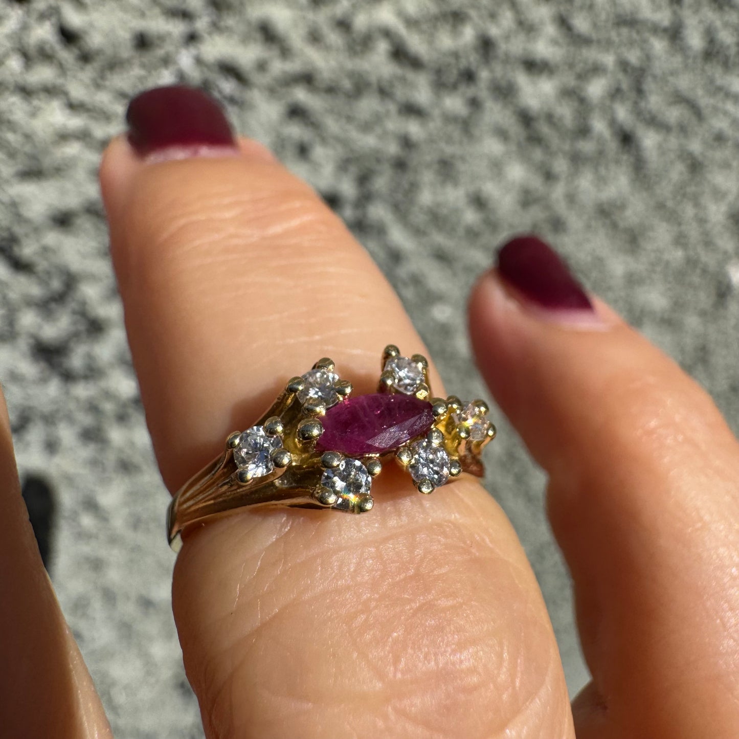 18K gold ring set with a marquise-cut Ruby accented by round Diamonds on each side.