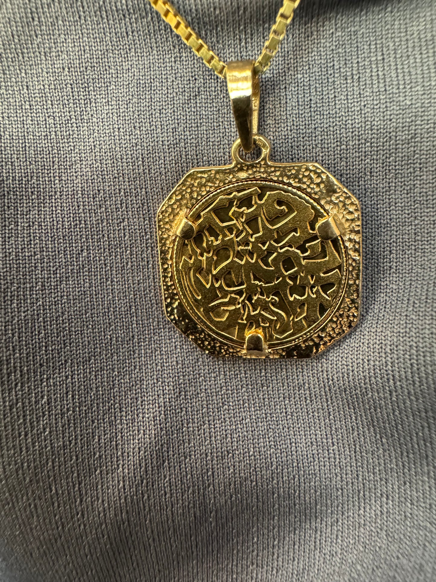 תליון זהב צהוב 14 קראט בעיצוב קלאסי עם נוכחות סמלית חזקה. במרכז התליון חריטה עדינה של עץ חיים, סמל לצמיחה, חיבור ושפע וכיתוב ״שמע ישראל״ ובצד השני אותיות ה-א״ב.