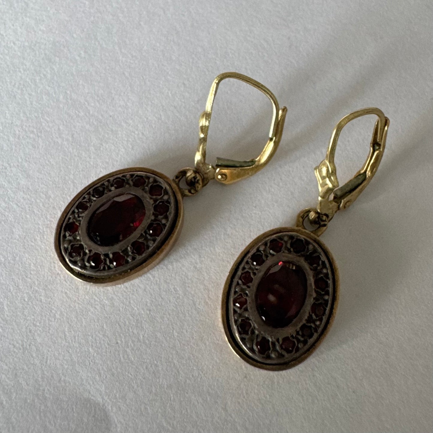 14K gold drop earrings set with deep red oval Garnets surrounded by smaller stones Garnets.
