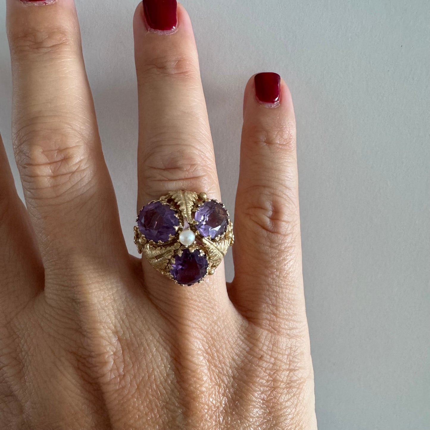 14K gold ring set with four glowing Amethyst stones encircling a delicate central Pearl.