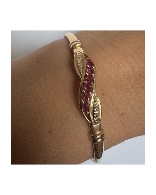 צמיד זהב 14 קראט בעיצוב אלגנטי ומיוחד, משובץ אבני רובי בגוון אדום עמוק לצד יהלומים קטנים המוסיפים ברק עדין.