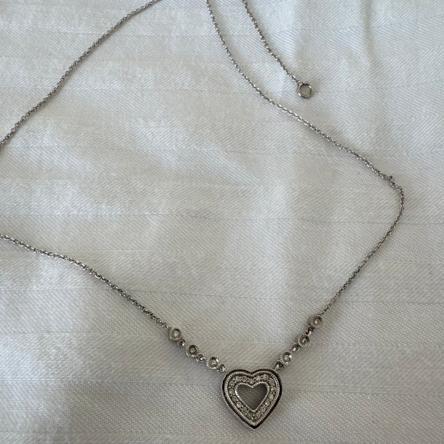 שרשרת זהב לבן 14 קראט משובצת יהלומים, בעיצוב לב עדין ומלא רומנטיקה.