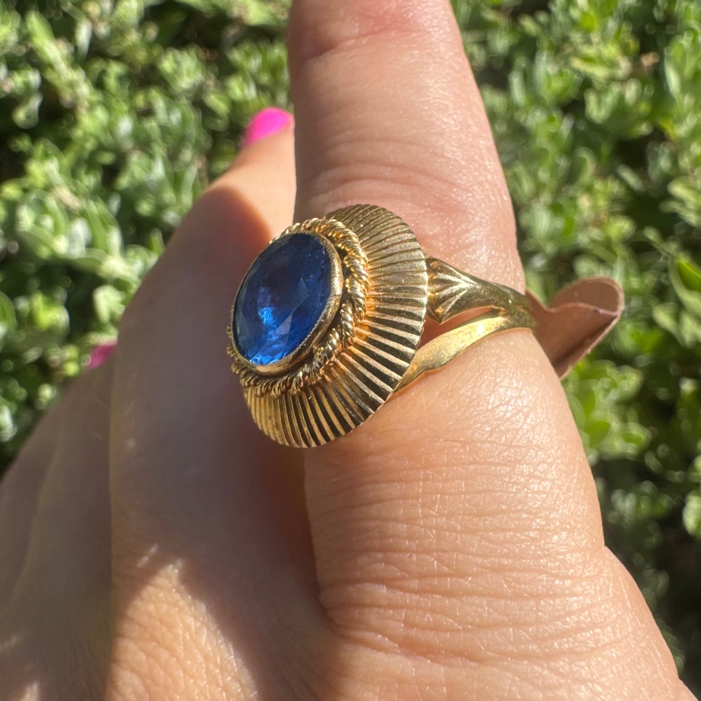 18K gold ring featuring a vibrant round Blue Topaz set in a textured gold bezel.