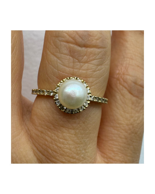 14K gold ring set with a central pearl and sparkling stones (not diamonds).