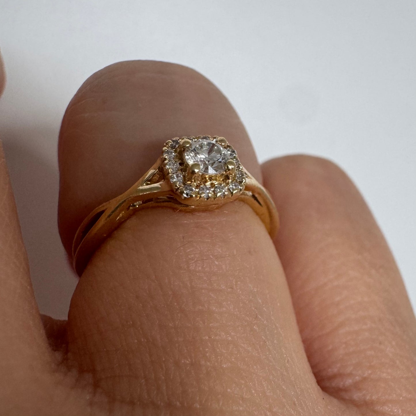 14K gold ring set with a central Diamond surrounded by small Diamonds
