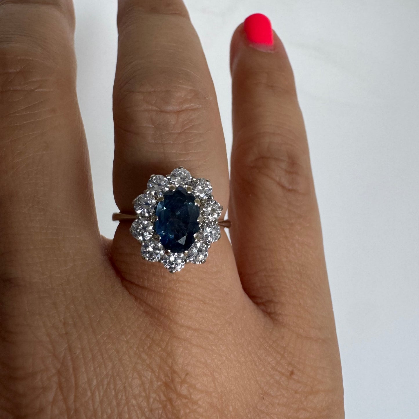 18K gold ring featuring a deep blue Sapphire at its center, surrounded by a sparkling halo of Diamonds