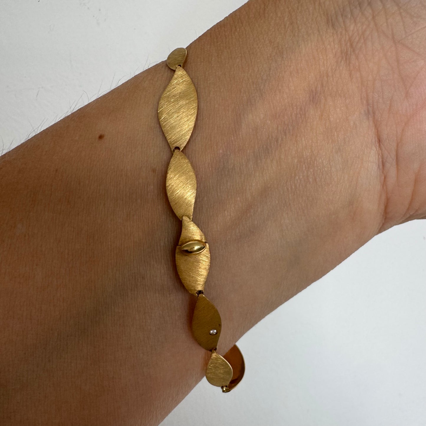 צמיד יוקרתי של המותג H.Stern, עשוי זהב 18 קראט, בעיצוב עלים מחוספסים במראה משי מט. 