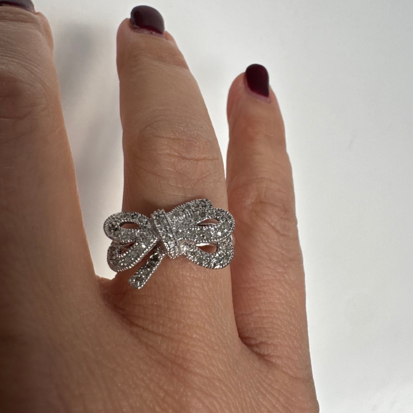 טבעת זהב לבן 14 קראט מעוצבת בצורת פפיון ומשובצת יהלומים בשיבוץ פאבה צפוף.