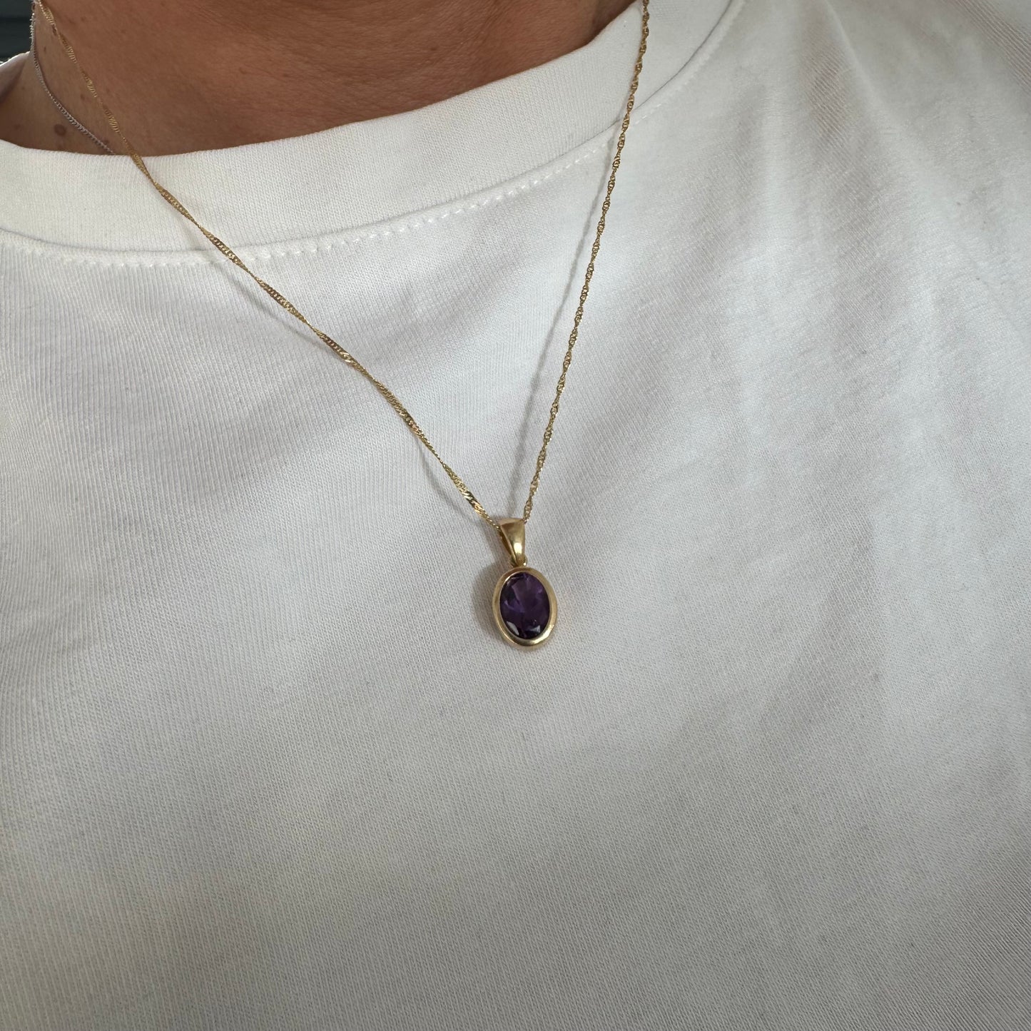 14K yellow gold necklace set with an oval-cut Amethyst in a smooth, classic bezel setting.