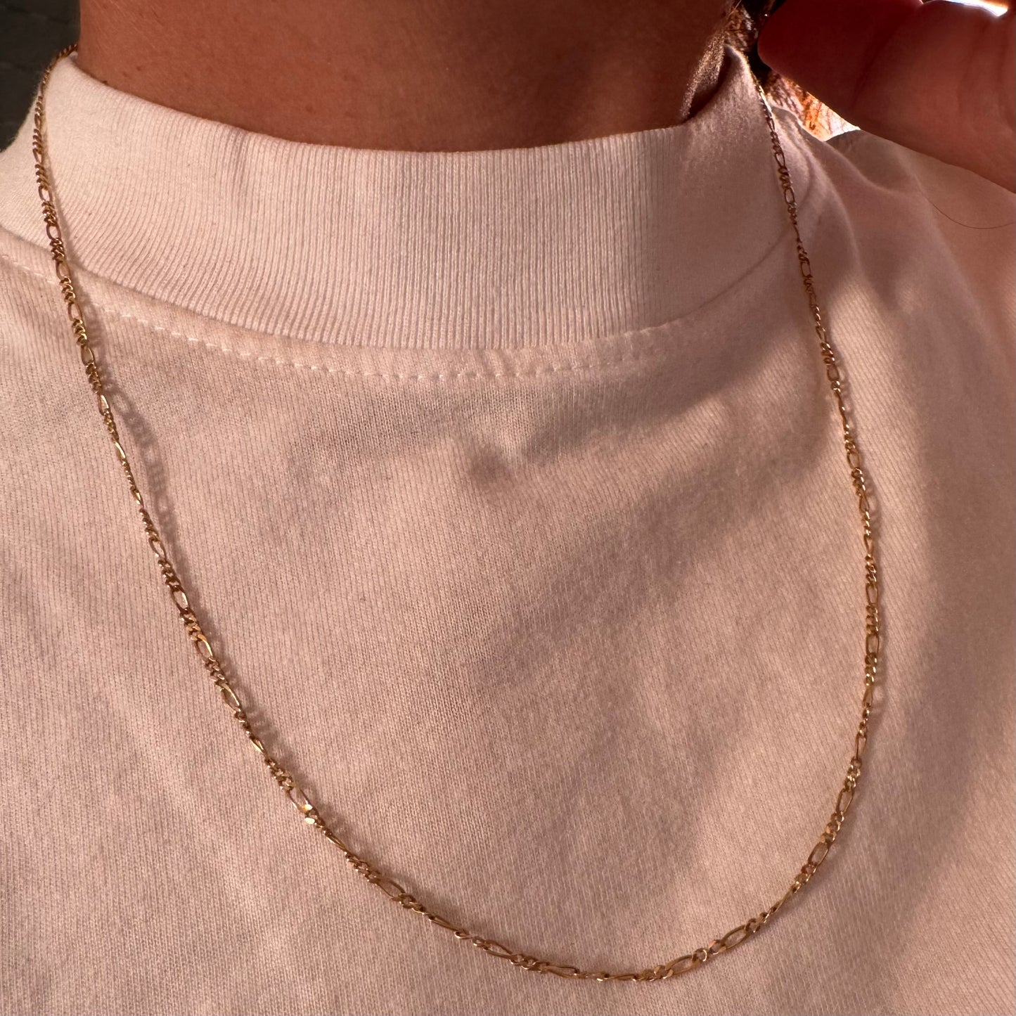 שרשרת זהב צהוב 14 קראט בעיצוב חוליות דקות ומוארכות עם טוויסט עדין שנותן לה מראה אלגנטי ונקי.