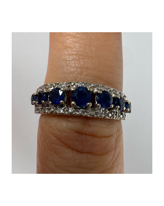 18K gold ring set with deep blue sapphires in a classic round cut, framed by two shimmering rows of brilliant Diamonds.