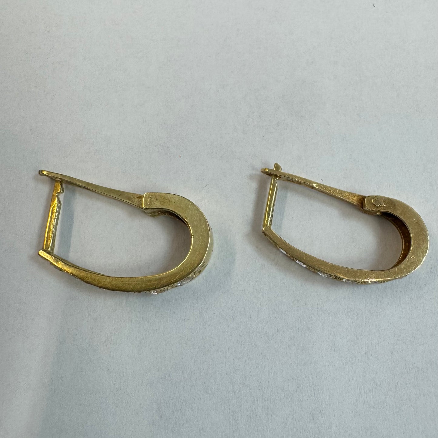 עגיל זהב צהוב 14 קראט בעיצוב אלגנטי ומודרני, משובץ שורת אבני חן שקופות שמעניקות ברק עדין ומדויק.