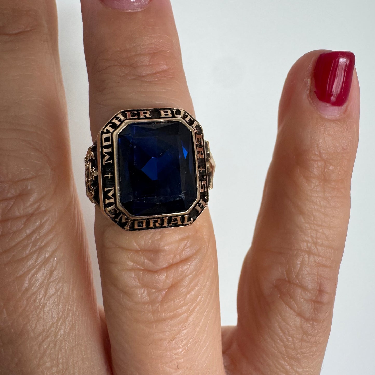 10K gold college ring set with a deep blue faceted stone.
