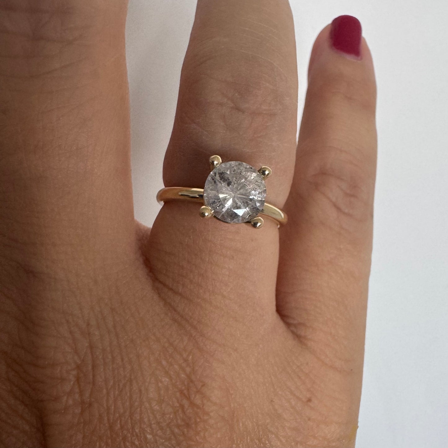 14K gold solitaire ring set with a central round Diamond