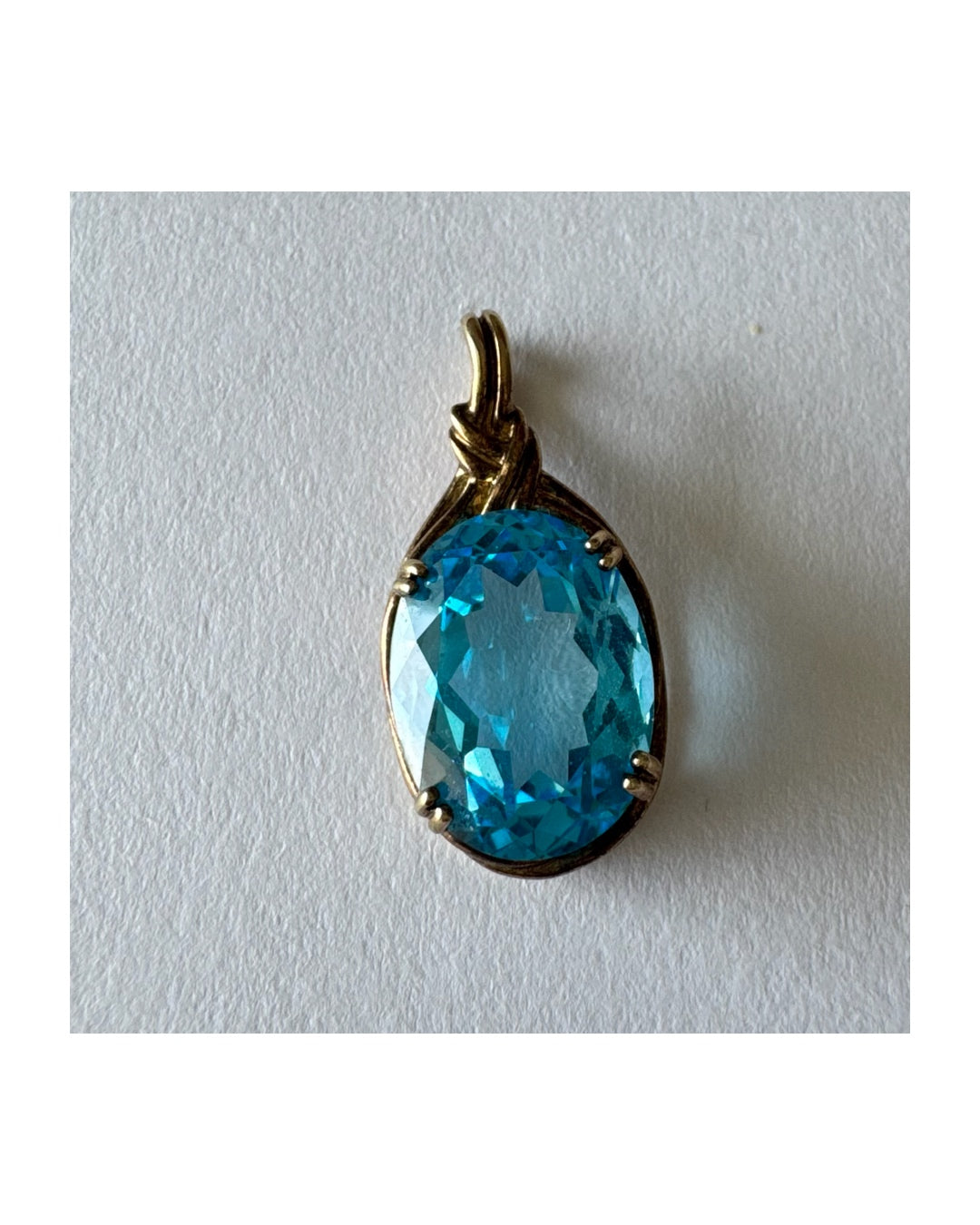 9K gold Pendant set with a striking oval-cut Blue Topaz