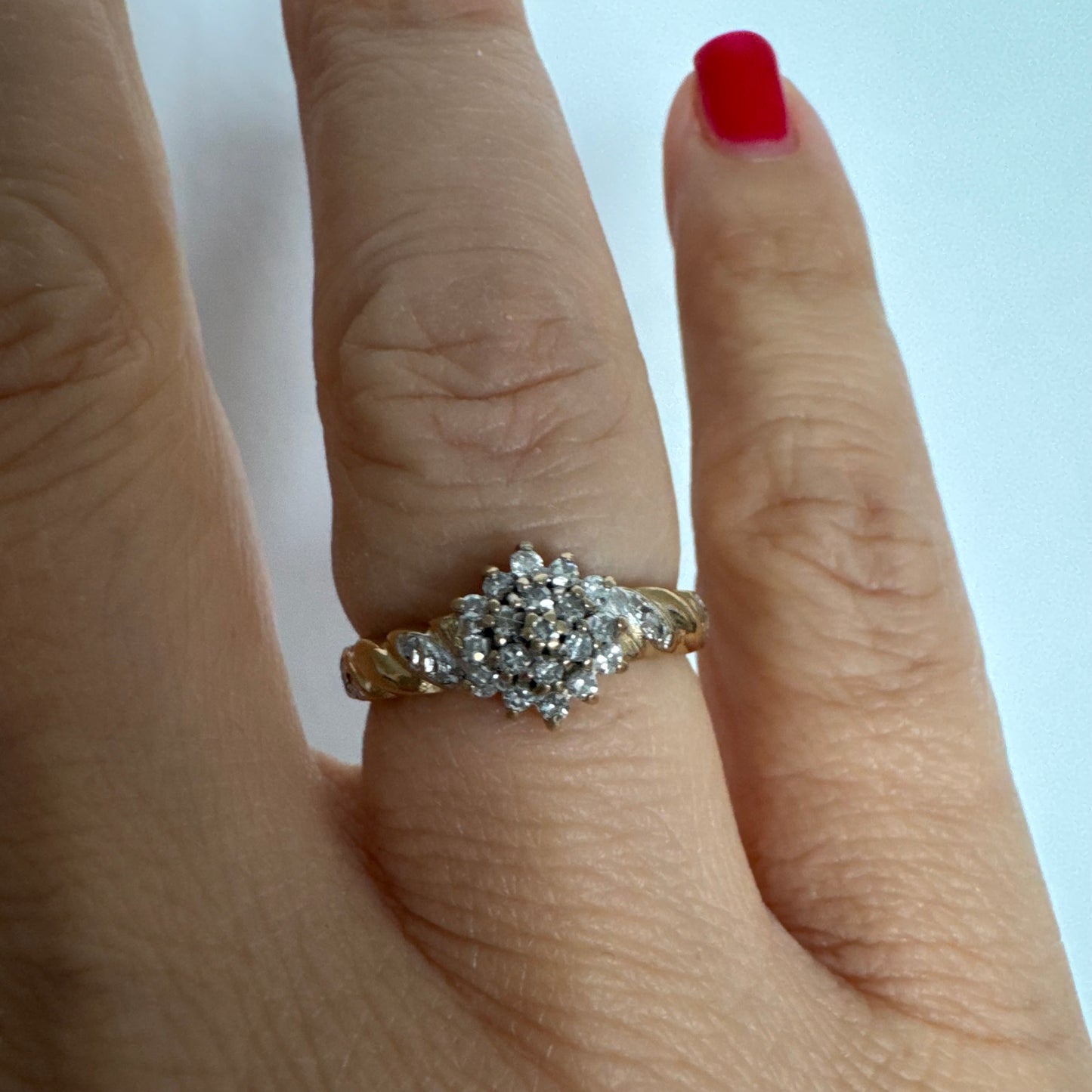 טבעת זהב צהוב 9 קראט משובצת יהלומים בעיצוב פרח עדין.