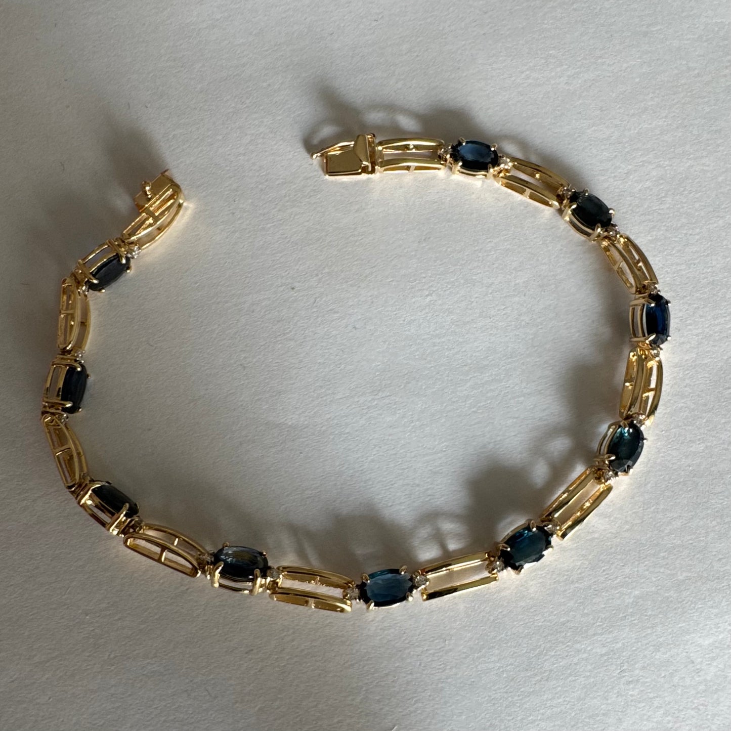 צמיד זהב צהוב 14 קראט משובץ אבני טופז כחולות בחיתוך אובלי, עם יהלומים המשובצים ביניהן להוספת ברק עדין.