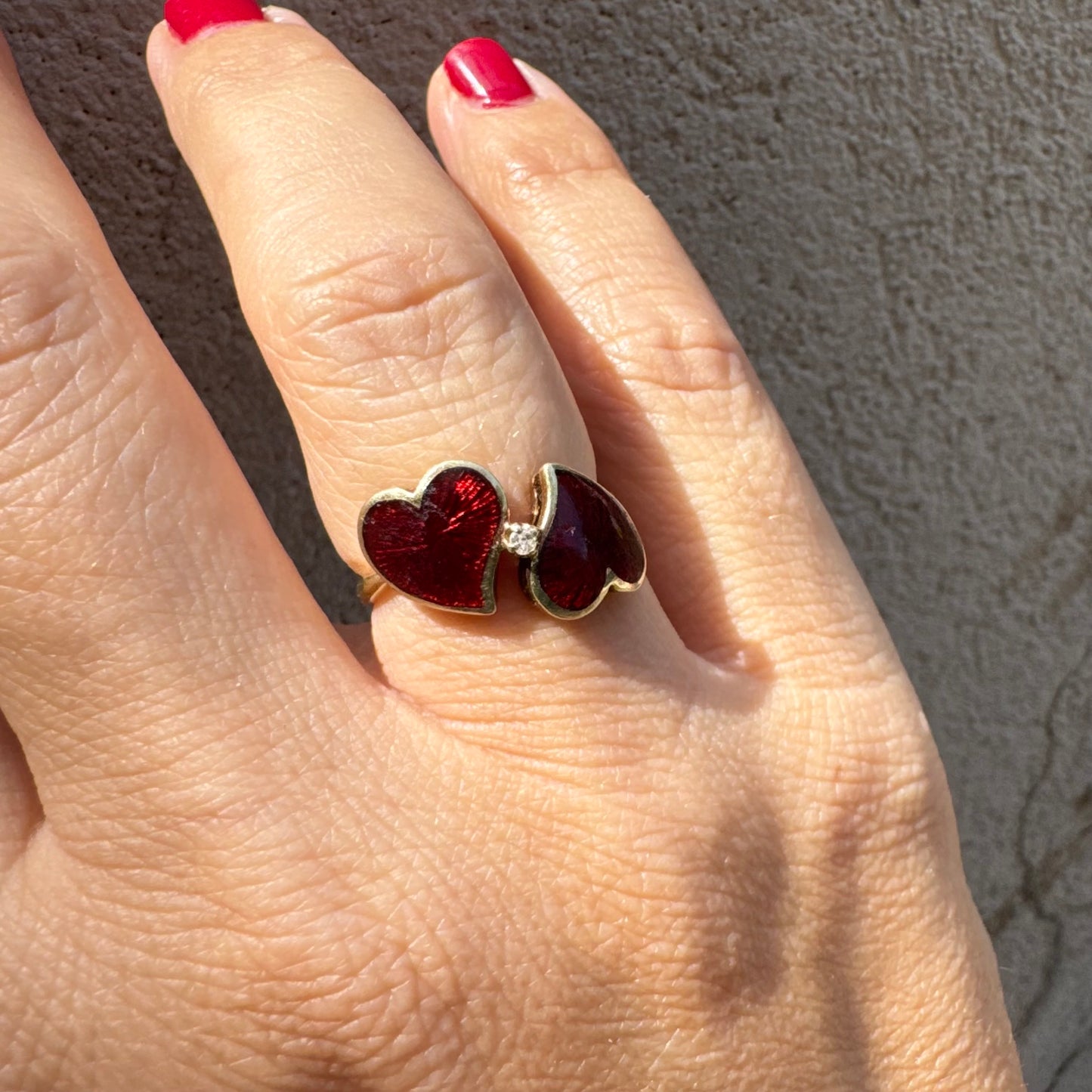 טבעת זהב צהוב 14 קראט “שני לבבות מחוברים״ מצופים אמייל אדום ויהלום משובץ במרכז