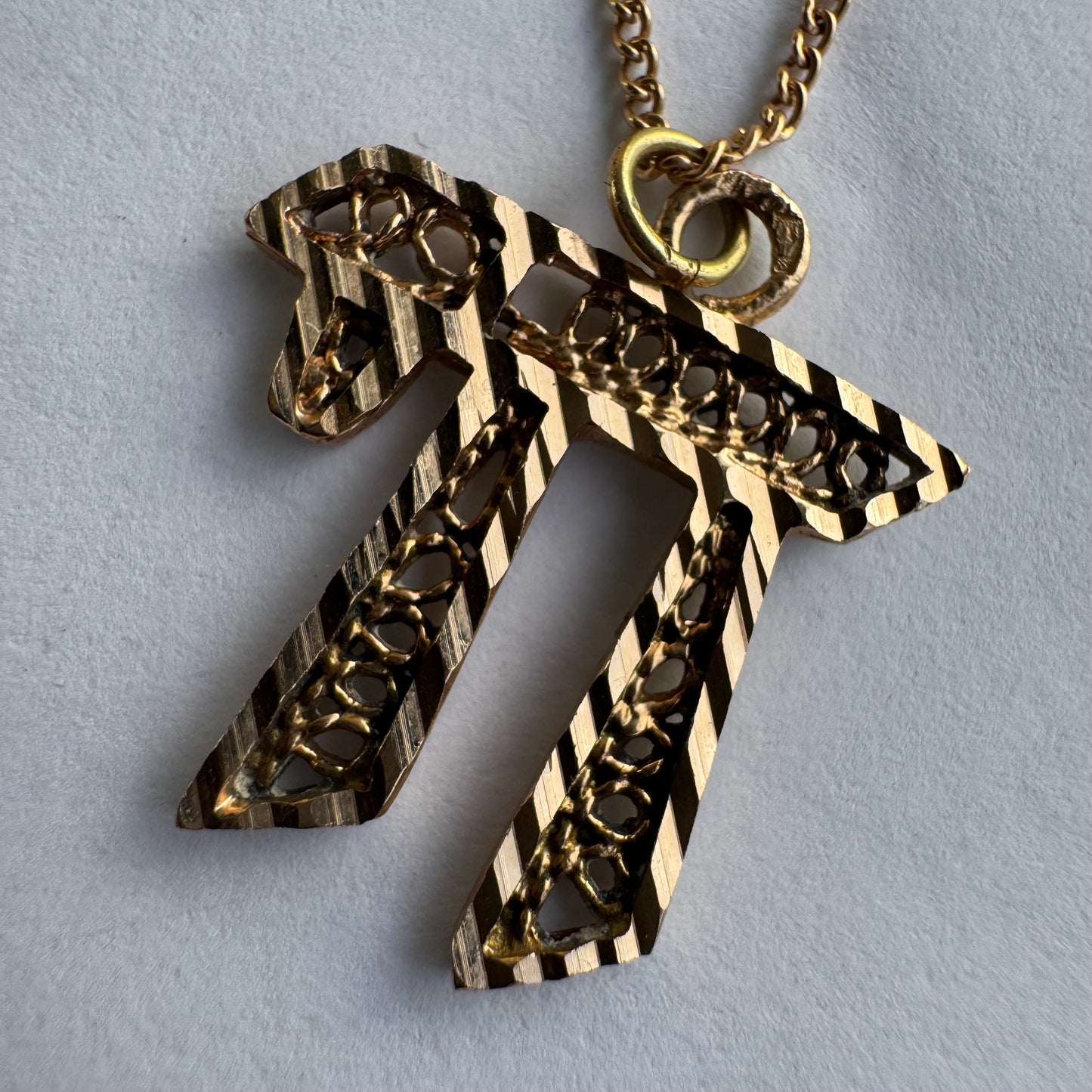 שרשרת זהב אדום 14 קראט עם תליון “חי״, בעיצוב גרפי ובעל נוכחות.