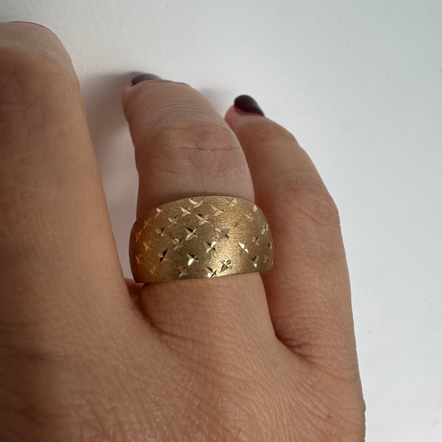14K gold wide signet-style ring with a matte finish and delicate star engravings.