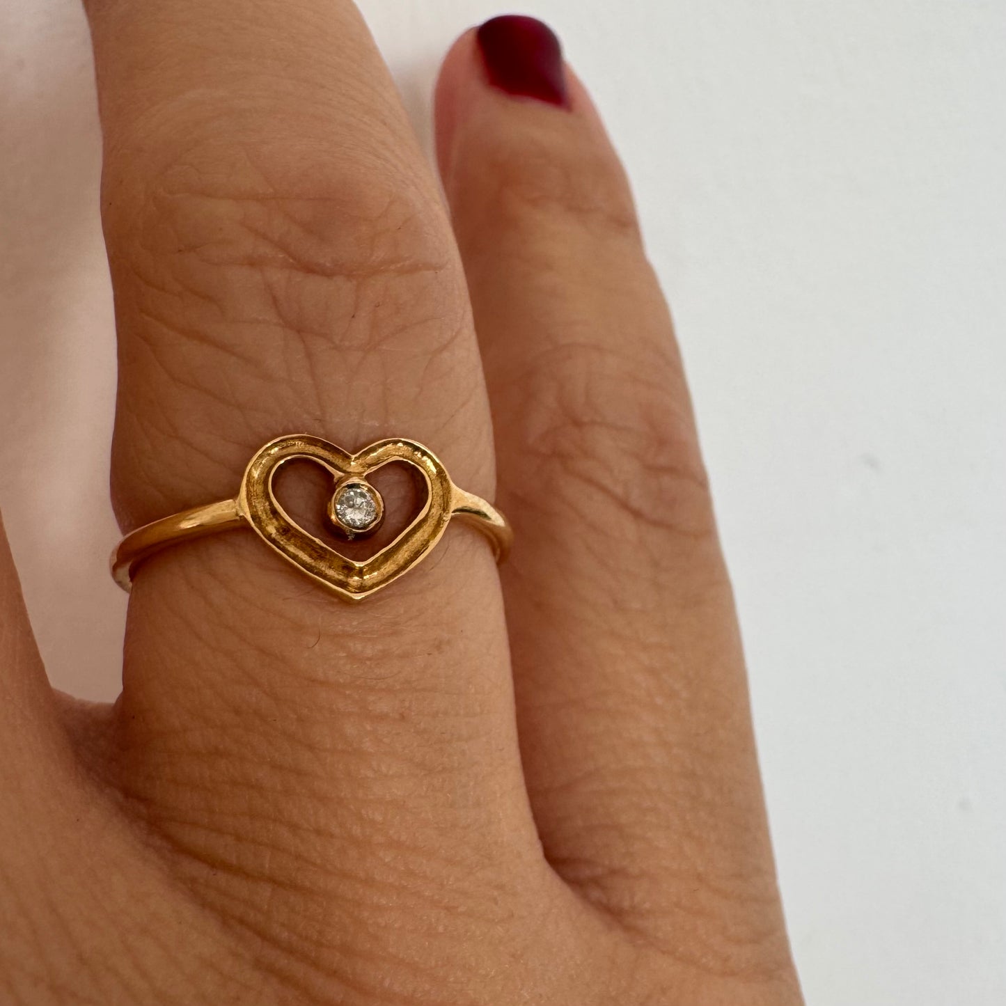 טבעת זהב 14 קראט בעיצוב לב פתוח ועדין, עם יהלום קטן במרכז שמוסיף נקודת אור אלגנטית. 