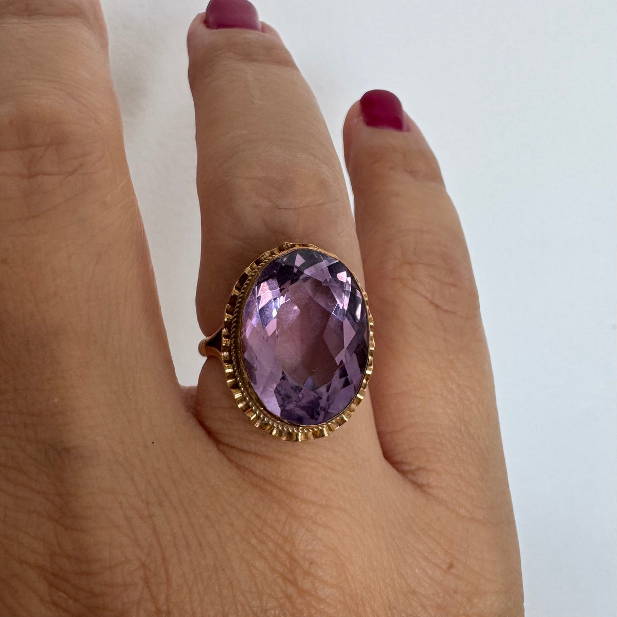 14K gold ring featuring a large oval-cut Amethyst set in an beautifully detailed gold setting