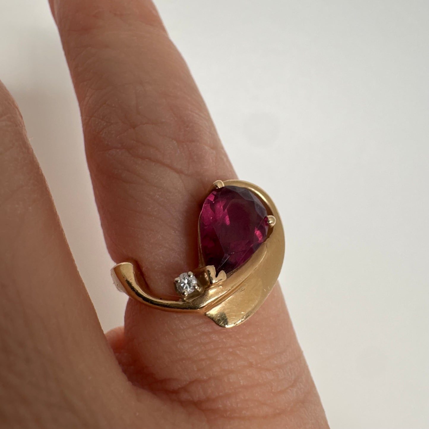 14K gold sculptural open ring set with a pear-cut pink Tourmaline, accented by a small Diamond.