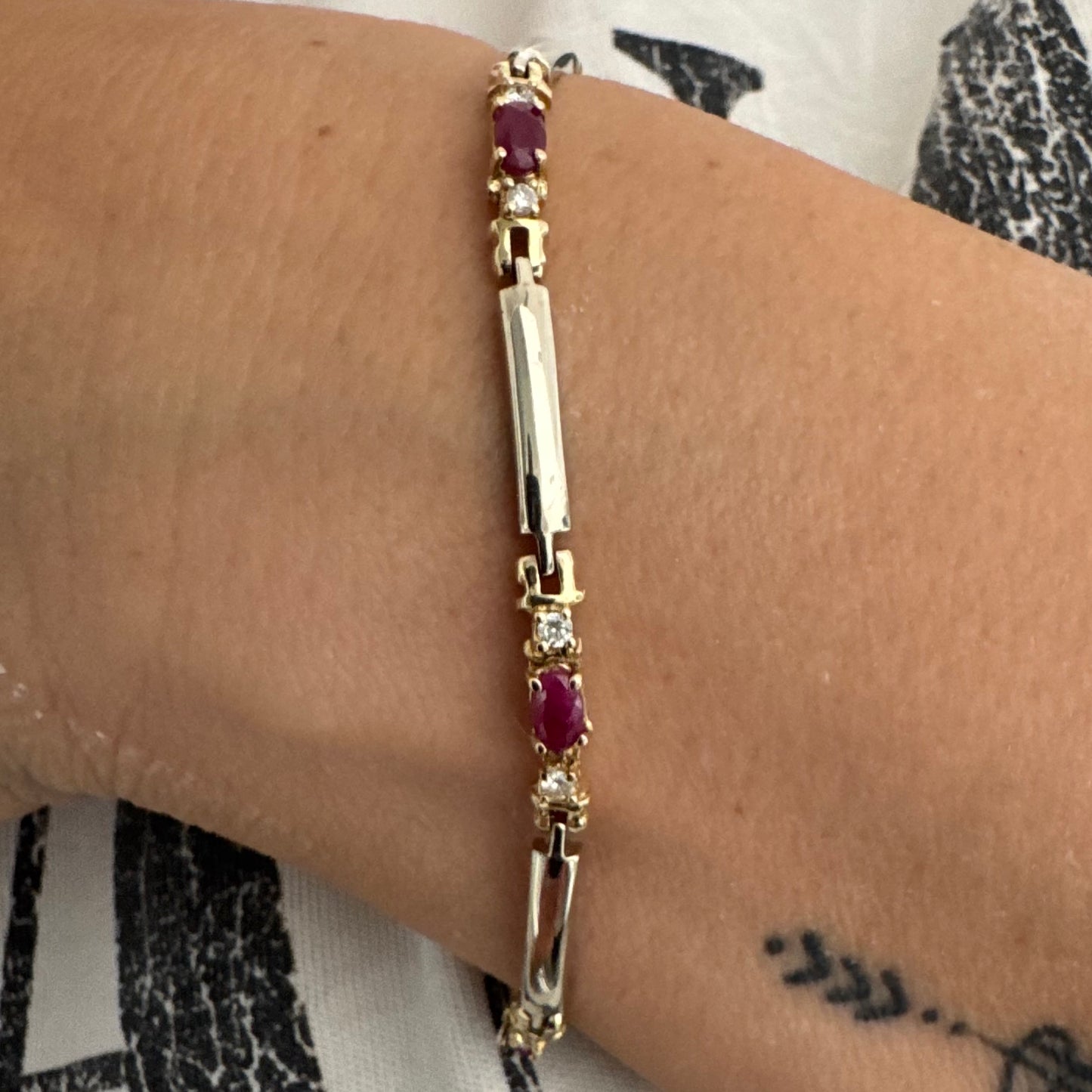 צמיד זהב צהוב 14 קראט משובץ אבני רובי אדומות בחיתוך אובלי, עם יהלומים המשובצים ביניהן להוספת ברק עדין.
