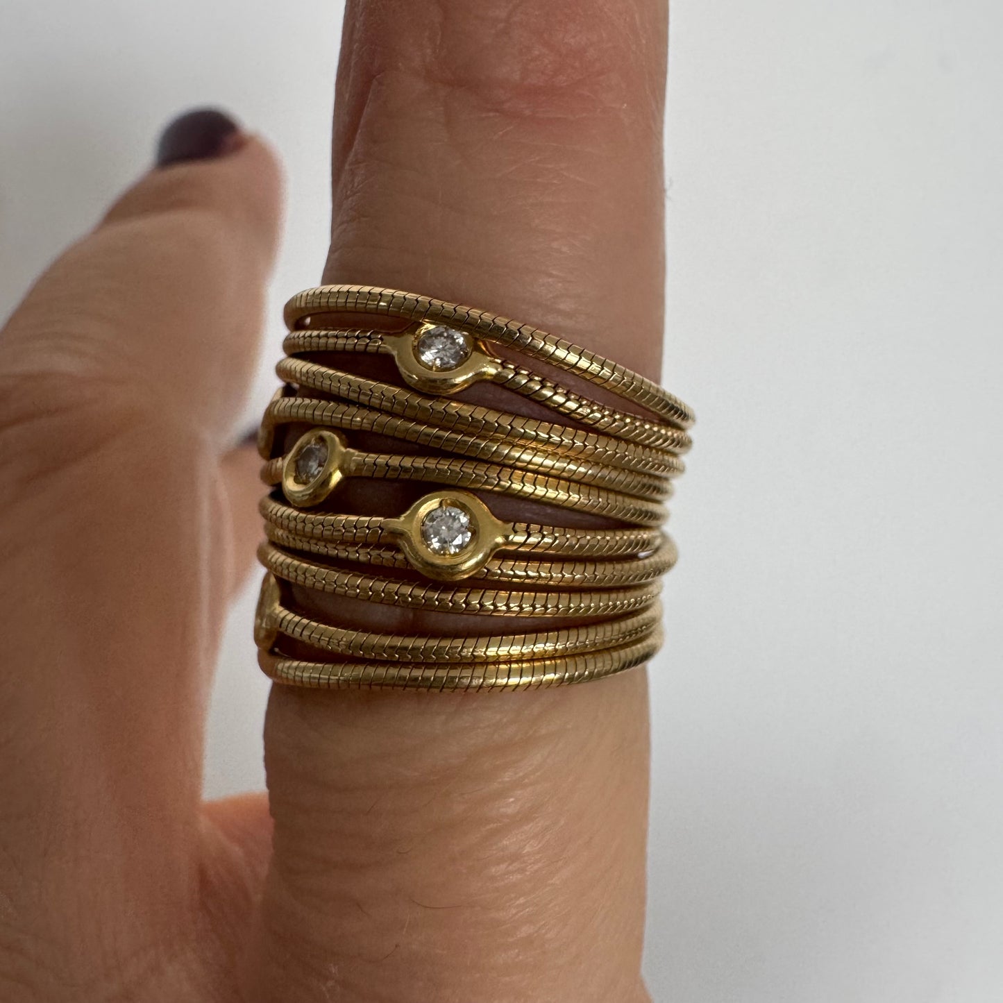 טבעת זהב צהוב 18 קראט של המותג H. Stern משובצת יהלומים בעיצוב רב־ליפופים אלגנטי 