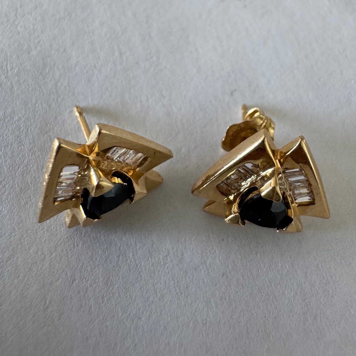 14K gold geometric stud earrings set with a Sapphire stone, surrounded by baguette Diamonds.