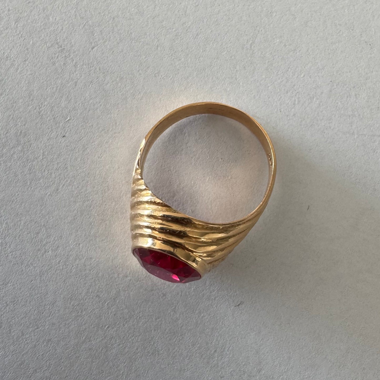 18K gold ring set with a striking oval-cut Ruby gemstone.