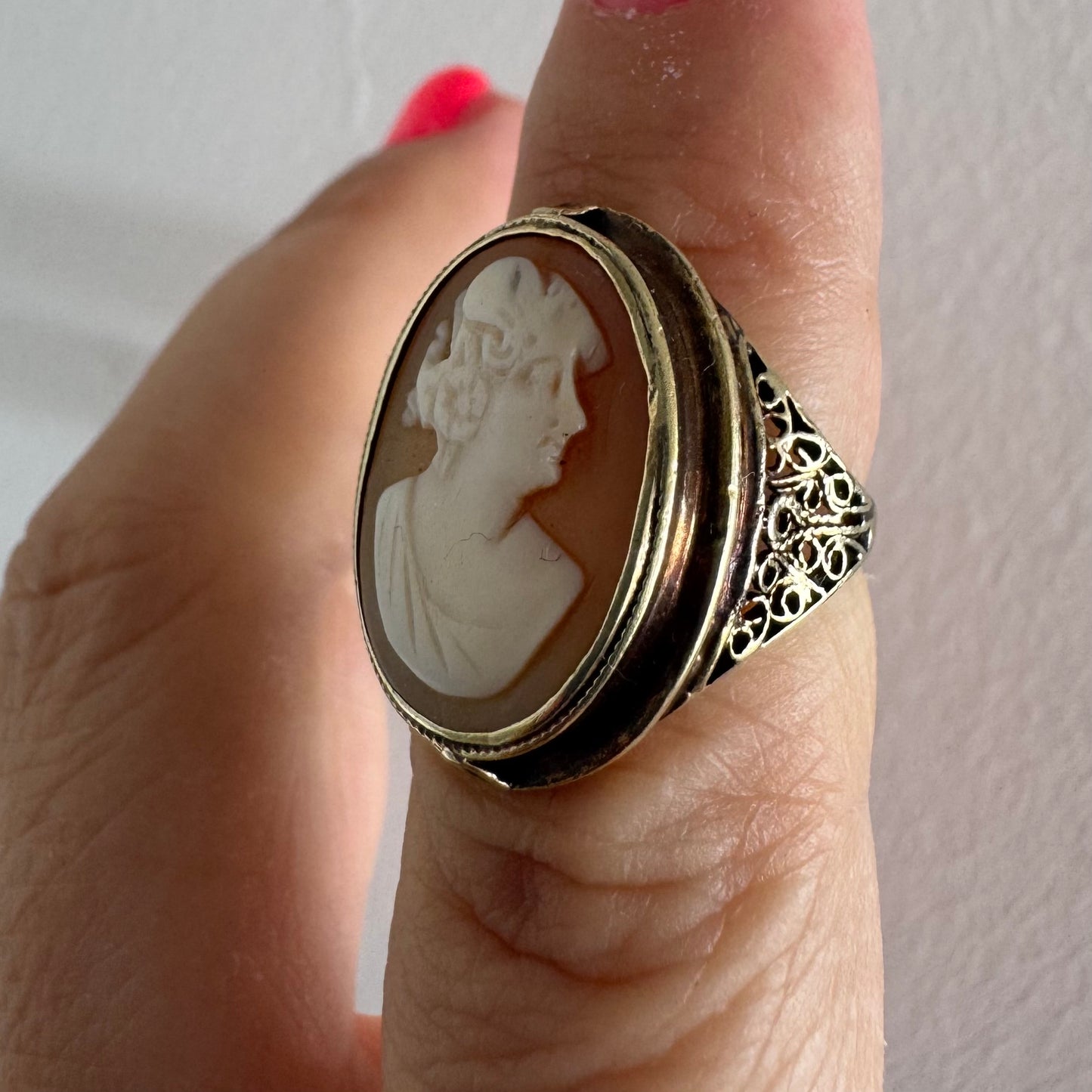 14K gold cameo ring featuring a finely carved portrait of a woman in profile, set in an oval bezel with intricate gold detailing