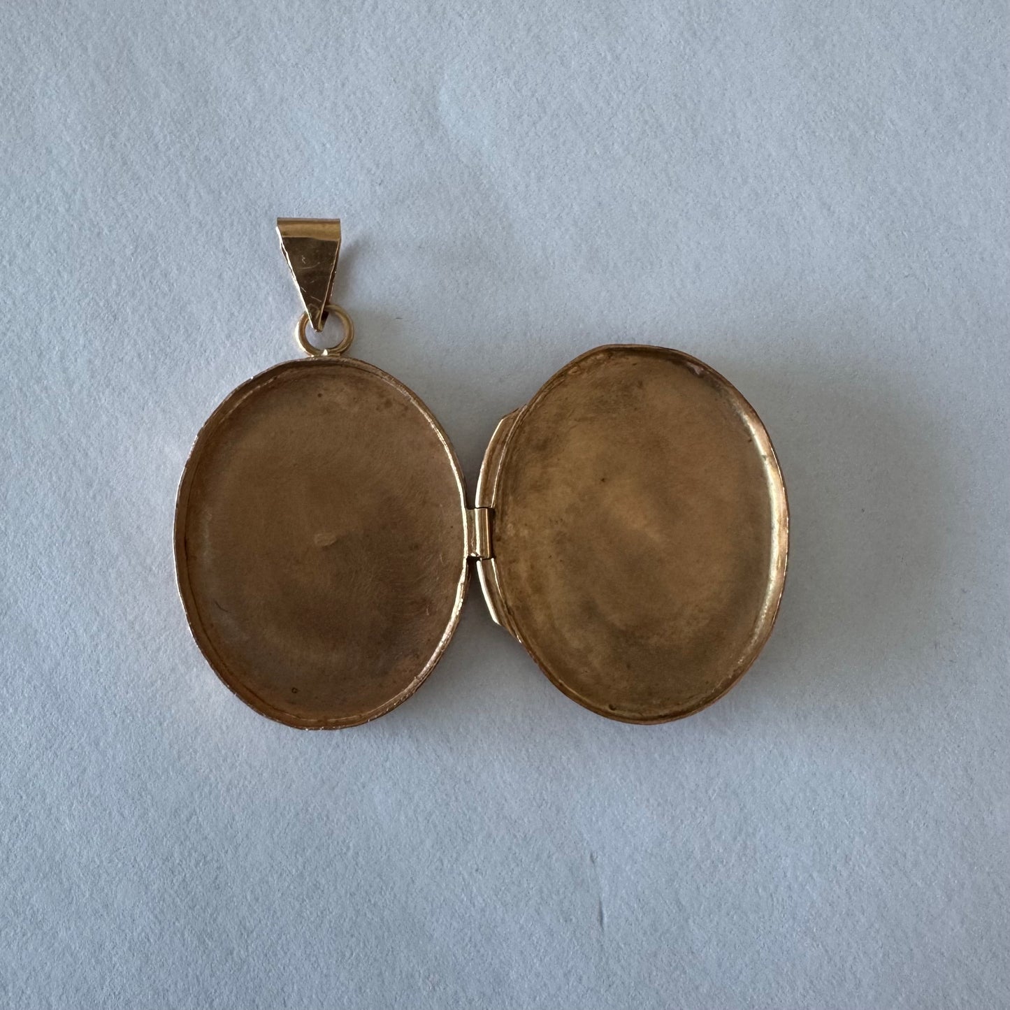 14K gold oval locket pendant delicately hand-engraved with floral motifs