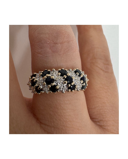 טבעת זהב צהוב 10 קראט משובצת אבני ספיר כהות ויהלומים בעיצוב קלאסי ורומנטי.