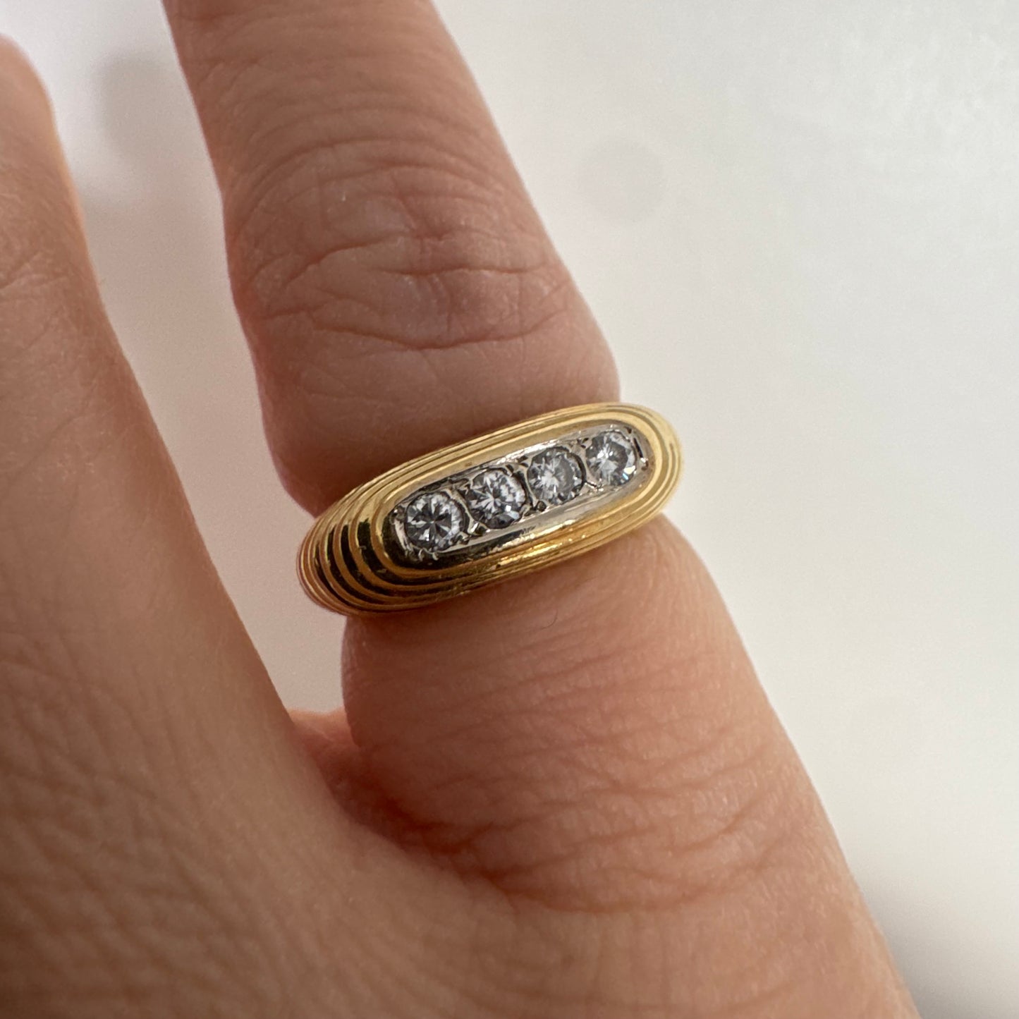14K gold elongated oval ring set with five round Diamonds in a channel setting.