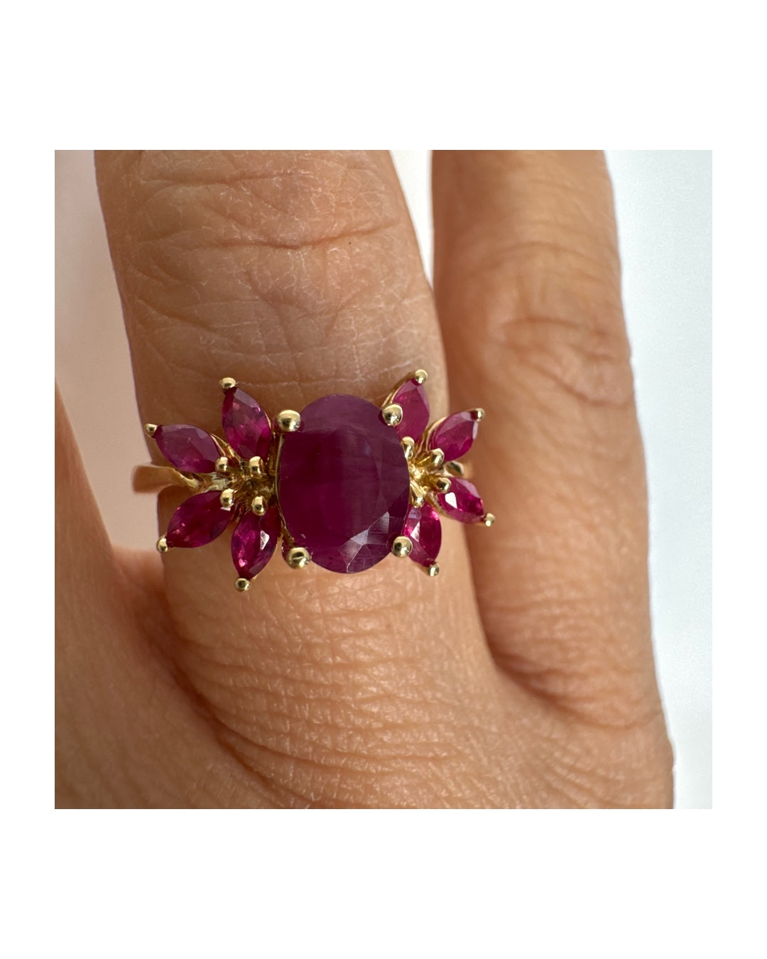 טבעת זהב צהוב 14 קראט משובצת רובי מרכזי גדול ולצידו רובי בחיתוך מרקיזה בעיצוב פרחוני עשיר.