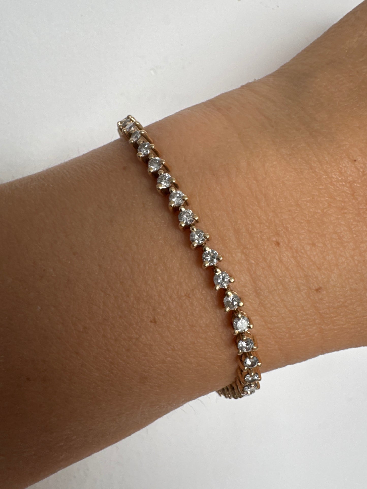 14K gold tennis bracelet set with a continuous line of round Diamonds, creating a delicate and elegant sparkle.